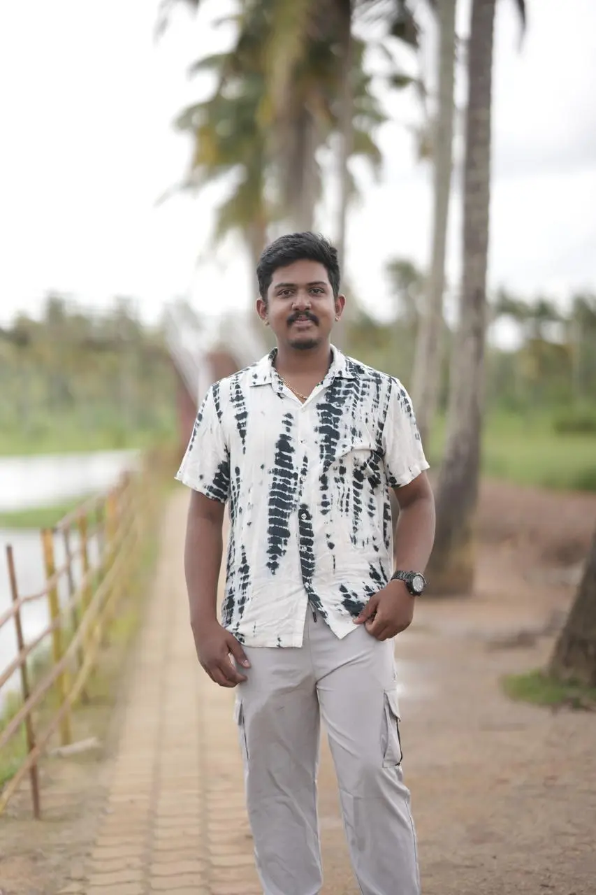 Man standing on a pathway with palm trees in the background of roi specialist in kochi